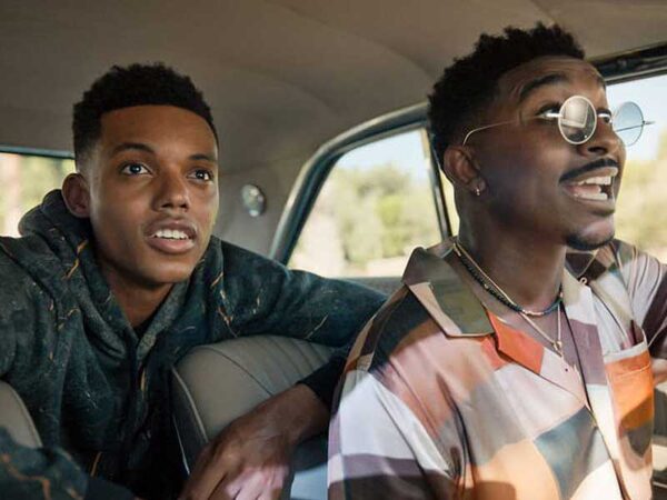 Two teenagers inside a car, staring with wide eyes and mouths